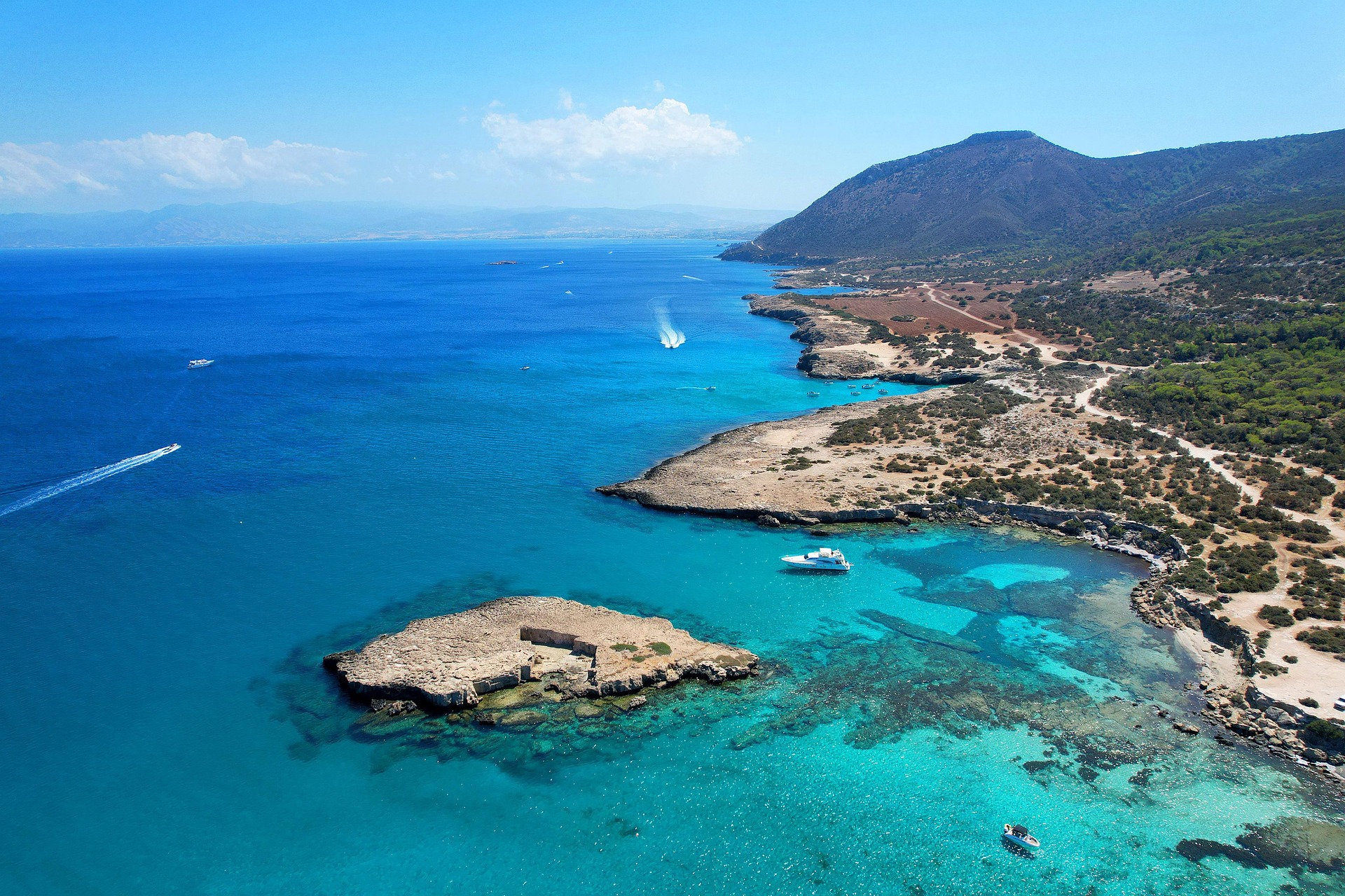 Vista aérea de la costa de Akamas con aguas turquesas y montañas al fondo